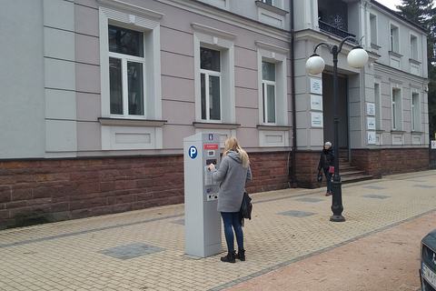 A girl with Solar parking meter near Koral Family Palace in Tomaszów Mazowiecki, Poland, EU