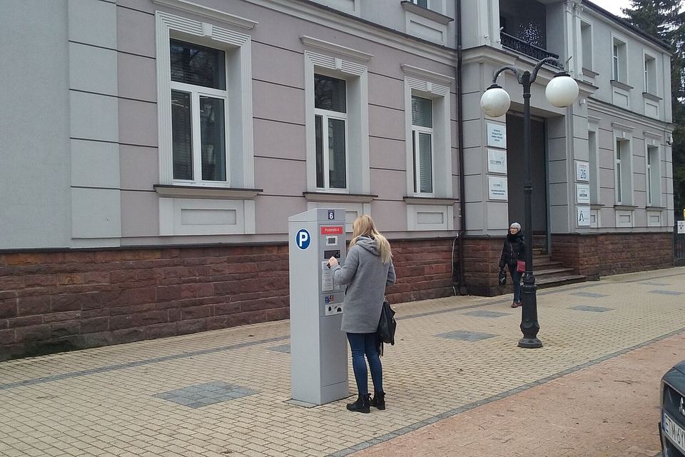 A girl with Solar parking meter near Koral Family Palace in Tomaszów Mazowiecki, Poland, EU